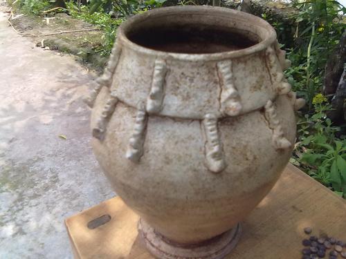 从古墓里挖出来的一个陶器,不知道是什么,罐子上一圈是9个翘起的图案