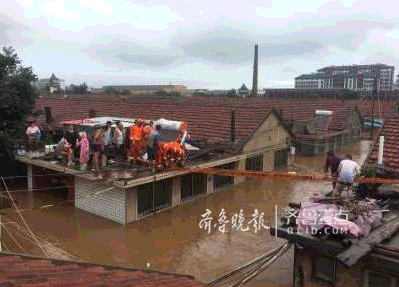 5日上午,莱阳市河洛镇枣行村,消防官兵正在搭建梯子营救被困房顶