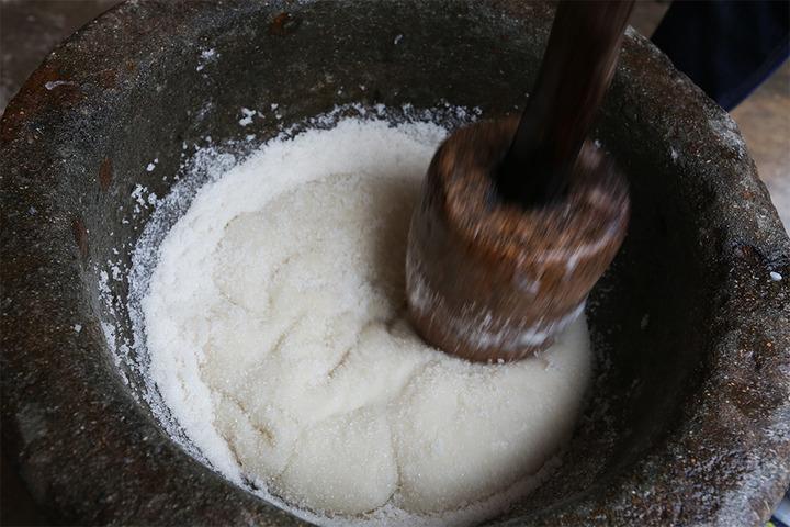 打时,把蒸熟的糯米,倒进石舂,三个人各握紧一根棒槌交替猛捣,捣烂糯米