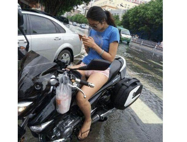 "美女骑电动车时要小心点,下雨天别光玩手机!"哈哈哈眼睛往哪看呢?