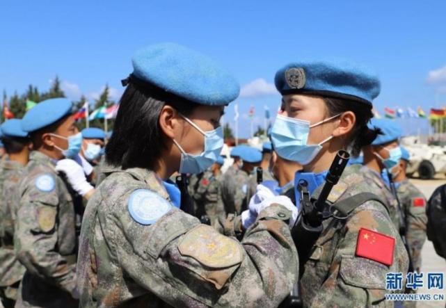 接受检阅的维和女兵进场前互相整理着装