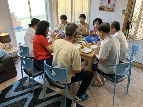 临时大家庭团团围坐吃晚餐,其乐融融