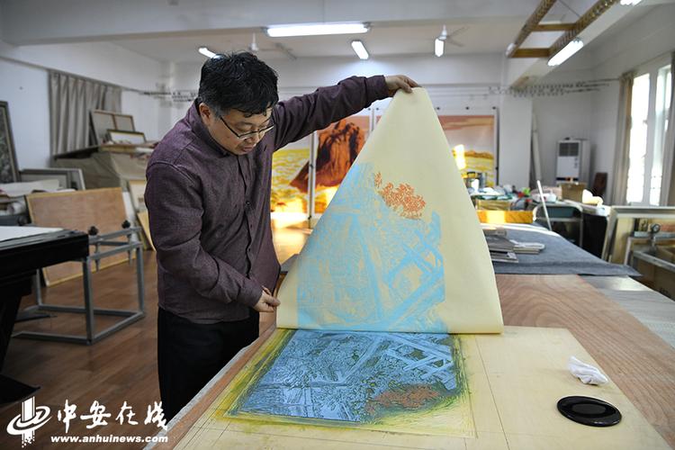 师晶正在展示版画制作的过程