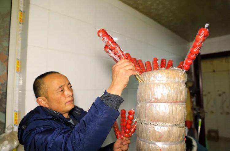李华勤将做好的冰糖葫芦插在草垛上,准备拿往集市销售早上七八点钟