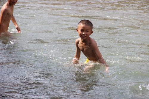 光屁股的小孩在河里游泳.忆自己的童年时光.