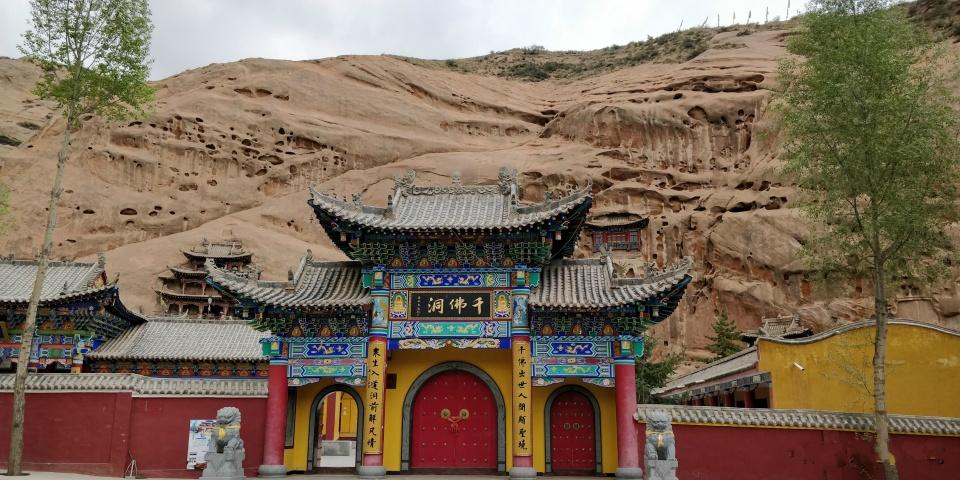 张掖有座石窟寺庙,佛殿凿在岩壁上,登高可望见祁连山风光