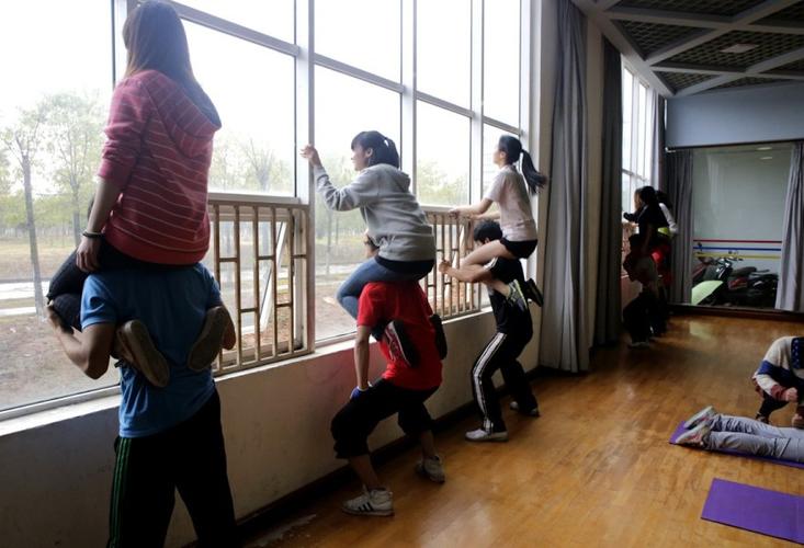 3月17日,湖北,教练让女生坐在男生肩膀上练习男生的腿力.