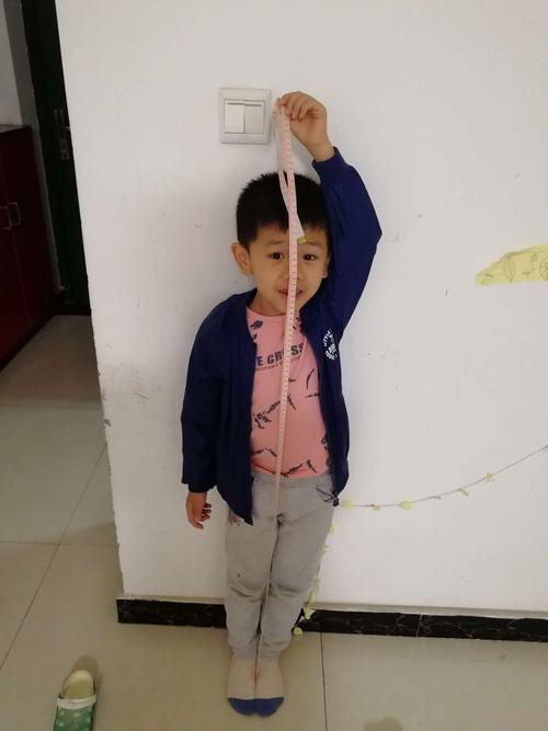 小朋友正在给自己量身高,是不是很棒呢?