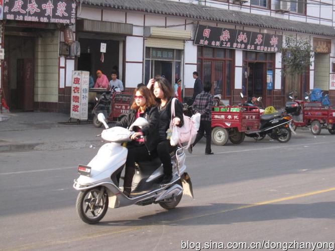 图六:古镇街道上从容骑行的机车女孩.