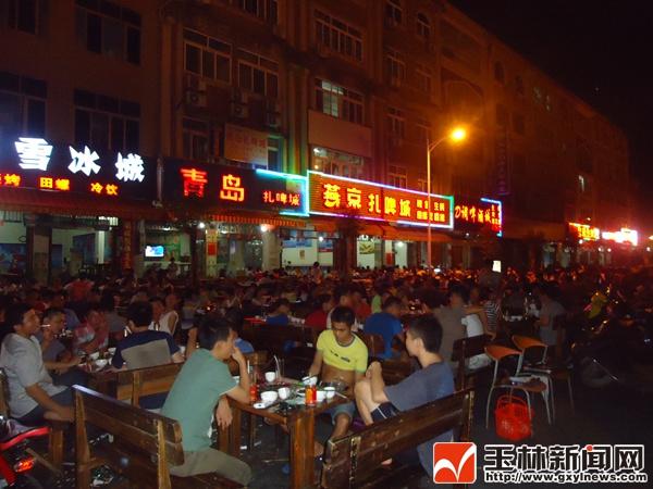 晚上接近11时,广场烧烤摊里的生意正火爆,几乎坐满食客.
