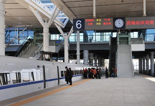 11月25日,工作人员在滨海站登上"试跑"中的津秦高铁动车组列车.