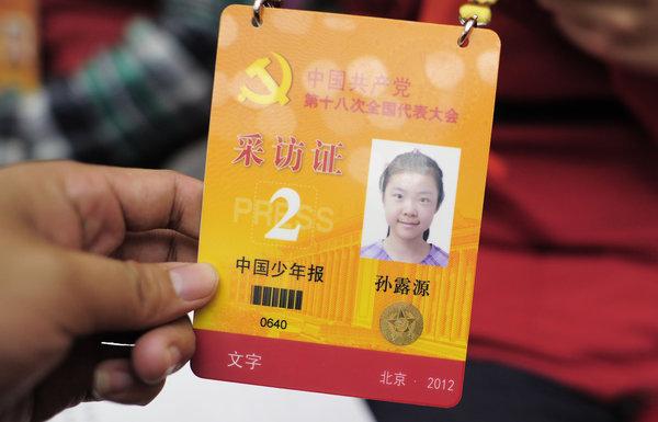 十八大花絮:小记者吸引老外目光; 图为:小记者的采访证; 11岁小记者跑
