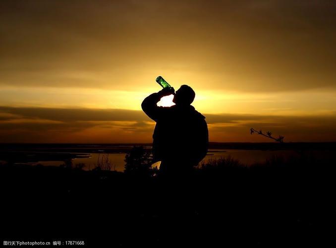 黄昏下海边喝酒的男人图片