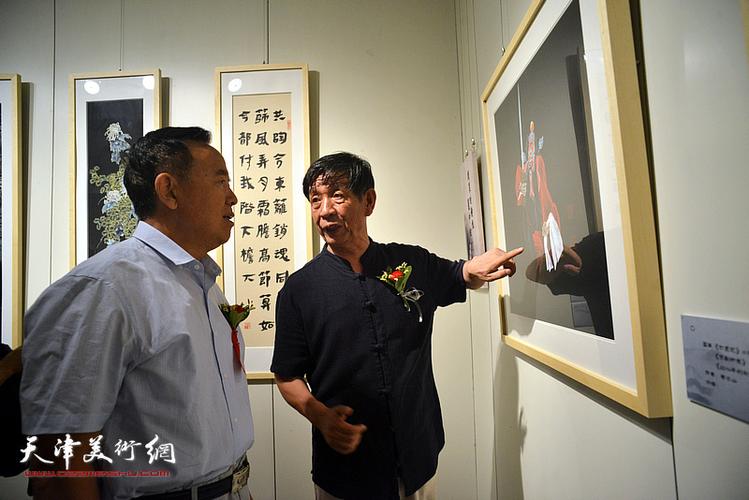 李尔山向孙辅智等嘉宾介绍画作.