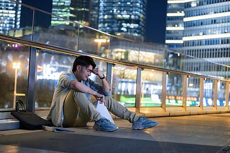 一个人落寞难过的心痛户外失业的男性青年背景