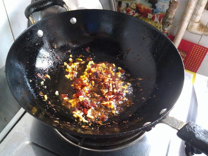 8.郫县豆瓣酱入锅小火炒香,加入葱,姜,蒜末爆香