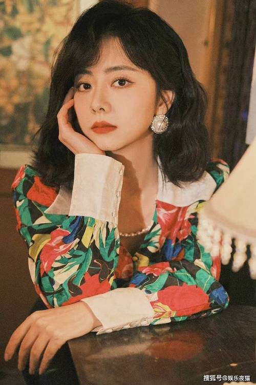 谭松韵身穿复古花衬衫搭配齐肩卷发,温柔可爱,珍珠项链,耳环点缀细节