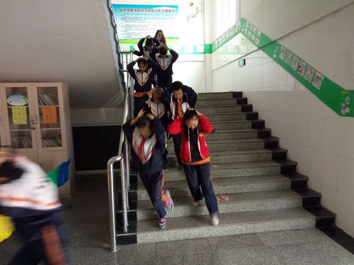 各班级学生按规定路线抱头快速下楼,前往紧急集合区域.