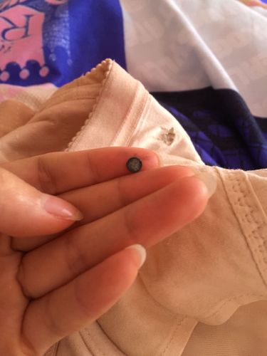 内衣中间缝了个黑色的东西,剪开发现是个黑色的像药