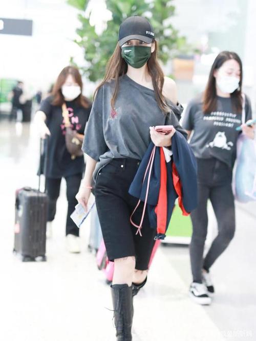 杨颖现身机场,穿单肩灰色上衣搭五分裤,穿长筒靴利用