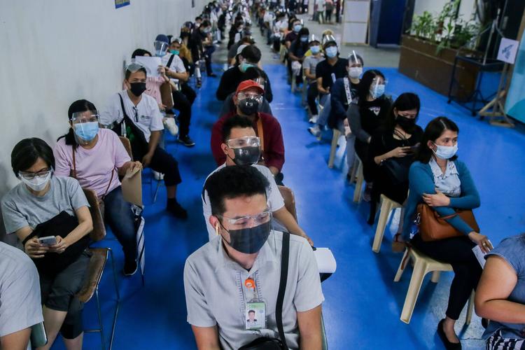 7月27日,在菲律宾圣胡安,人们排队等待接种新冠疫苗.