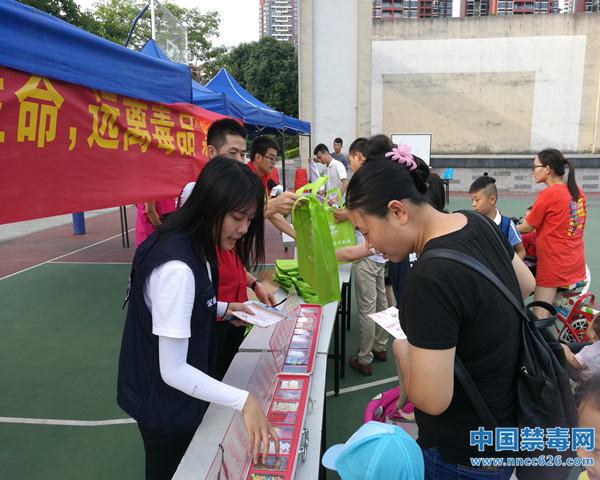 图为禁毒社工为社区居民讲解毒品知识.中国禁毒网发