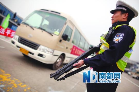 昨日,交警配枪执勤,对过往客车进行检查. 南都记者 王子荣 摄