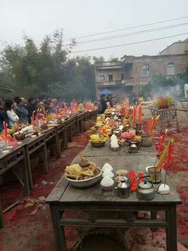 伴有糖果,三茶五酒和香烛供奉在八仙桌上 居中在一处一起拜神