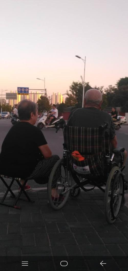 一辆轮椅一把马扎一对老人,一缕夏未初秋的阳光.