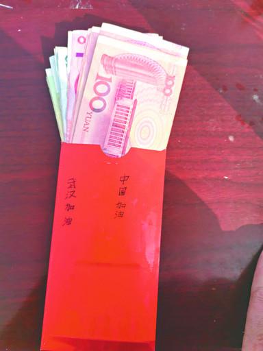 一男童跑到浚县古城南城门卡点 放下装有939元现金红包 说完"捐给武汉