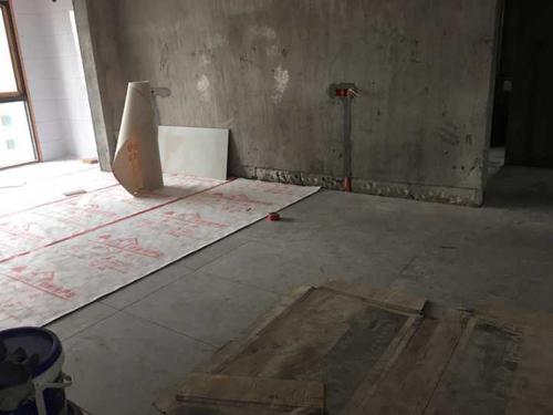 客厅贴好地砖,正在铺地面保护膜