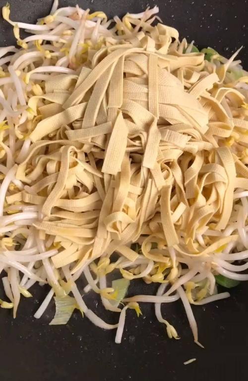下入豆芽和干豆腐翻炒均匀