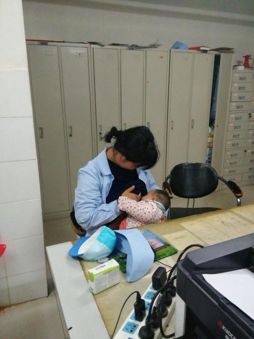 护士张晓瑞昨晚夜班,因科室忙主动要求加班,爱人把宝宝抱到科室喂奶.