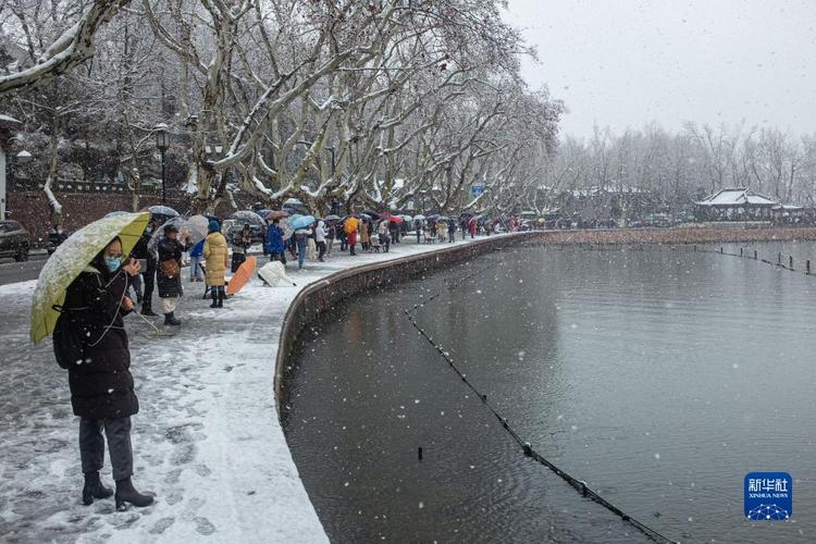 当日,浙江省杭州市迎来降雪,西湖景区迎来众多观赏雪景的游客.