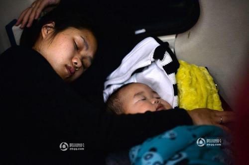 临客列车上,妈妈将孩子围在自己的胳膊里相互依偎度过难熬的坐票