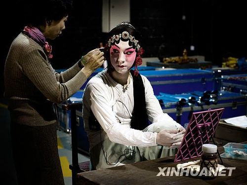 男旦演员刘铮(右)在妈妈的帮助下整理衣装准备演出(10月19日摄).