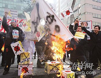 愤怒的韩国民众燃烧日本国旗泄愤.