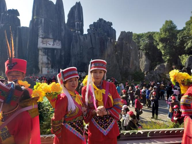 不少外地游客也穿着少数民族服装在石林景区拍照.