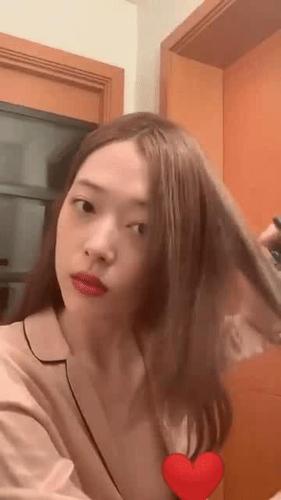 直播中的雪莉身穿宽松深v的外套,边和粉丝们交谈,边卷头发.