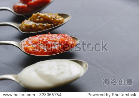 on vintage spoons on slate background mayonnaise tomato sauce