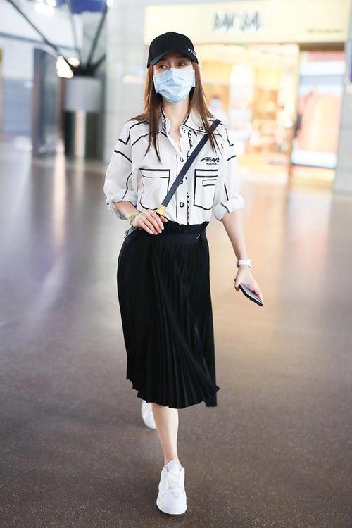 angelababy现身机场,白色涂鸦衬衫搭配黑色百褶裙,简约不失气场