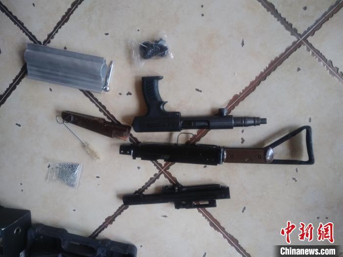 图为民警缴获的枪支弹药.