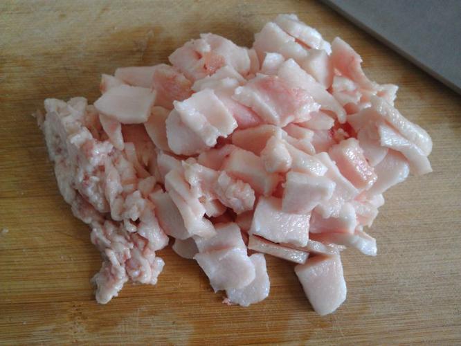 锅中倒适量水,中火加热,将肥肉片入锅煎熬; 待锅中水烧开,不停搅动