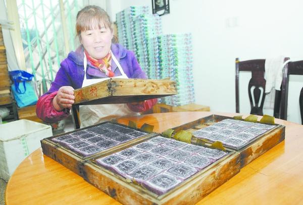 近日,在梁弄镇阿桥大糕店里,用黑米为原料制作的梁弄大糕出炉了.