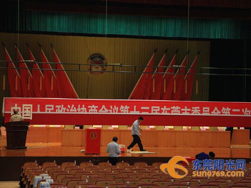 后勤工作人员在更换横幅为下场会议做准备