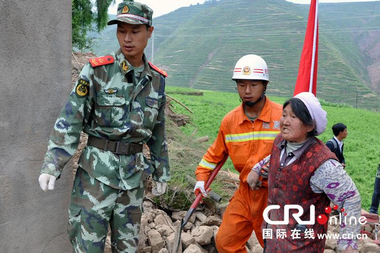 图为武警消防部队官兵帮助受灾村民排险和抢救物资.肖中仁摄