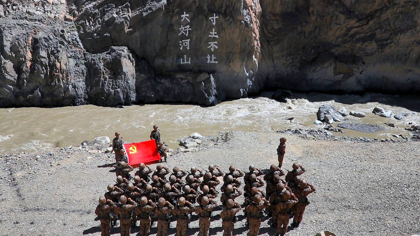 团官兵在"大好河山 寸土不让"标语前举行重温入党誓词仪式(资料照片)