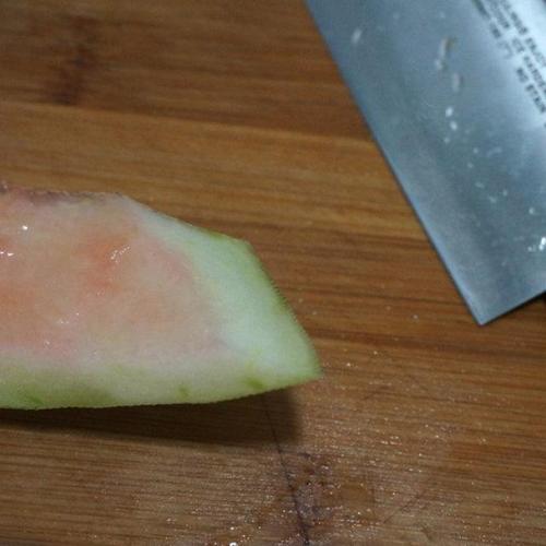 第3步,刀倾斜30度角,可以让西瓜皮更宽些,如果不想要宽片,刀就直立着