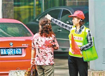 5月8日,江北区观音桥环道,交通文明劝导员为问路的市民指点道路.