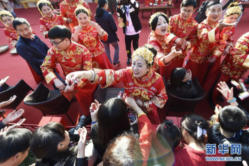 11月9日,参加婚典的新人们在婚礼仪式上向观众分撒喜糖.